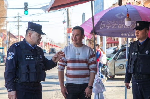 图为沙帕尔・艾力坎木与民警在辖区商铺开展走访排查工作。 .jpg